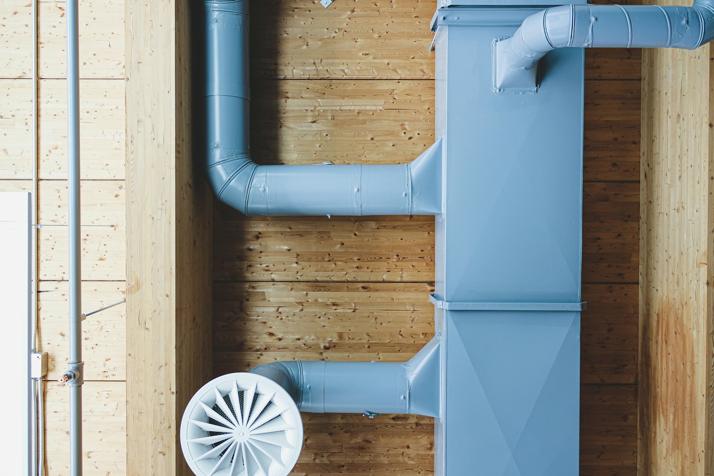 Condotti di ventilazione industriali contro assi di legno.